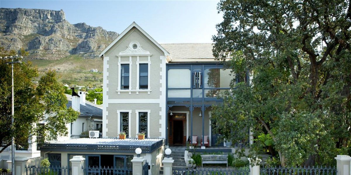 The charming facade set against the emerald mountain backdrop at Welgelegen Boutique Hotel, Cape Town, South Africa